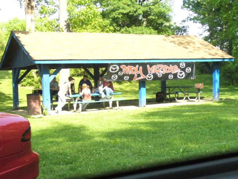 1991 Ford Probe - A group of people are gathered under a picnic shelter with a banner displaying 'MDY MAZDAS'.