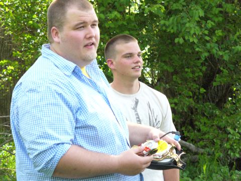 1991 Ford Probe - Two men are outdoors holding a disassembled remote control car part.