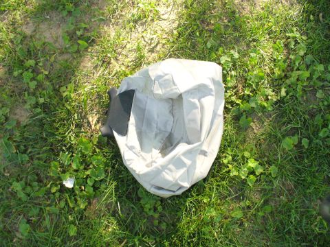 1991 Ford Probe - A car cover is shown resting on a patch of grass, with a dark trim piece peeking out from underneath.
