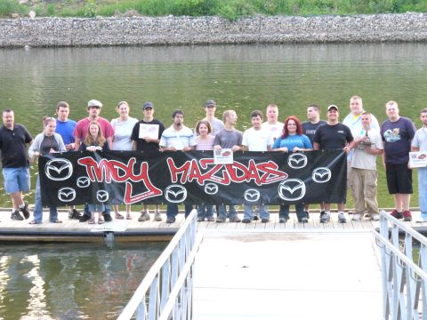 1991 Ford Probe - A group poses for a photo on a dock, holding a banner that reads "Indy Mazdas".
