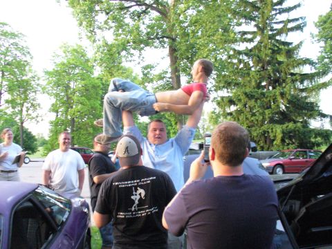 1991 Ford Probe - A group of people are gathered outdoors, with one person being lifted in the air by another. A shirt reads 'Tennessee Probe Owners Club'.