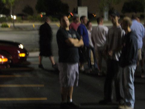 1991 Ford Probe - A red car is partially visible in the foreground, with a group of people standing in the background.