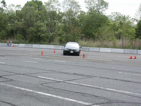 2001 Mercury Grand Marquis - A black sedan navigates a course marked by orange cones on a race track.