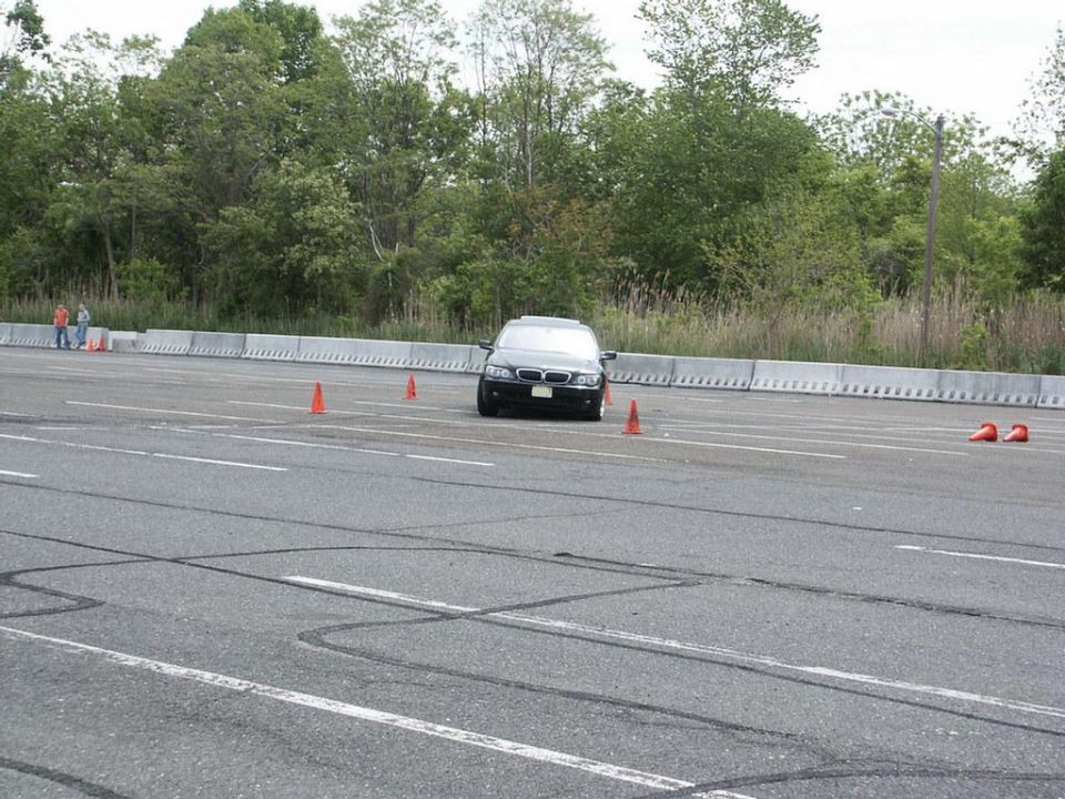 Black sedan on race track with orange cones