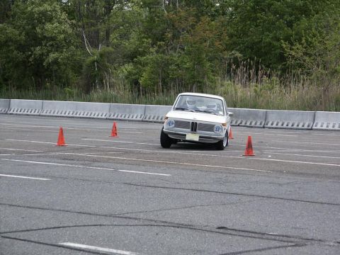2001 Mercury Grand Marquis - A white BMW 2002 is seen on an autocross course, navigating around orange cones.