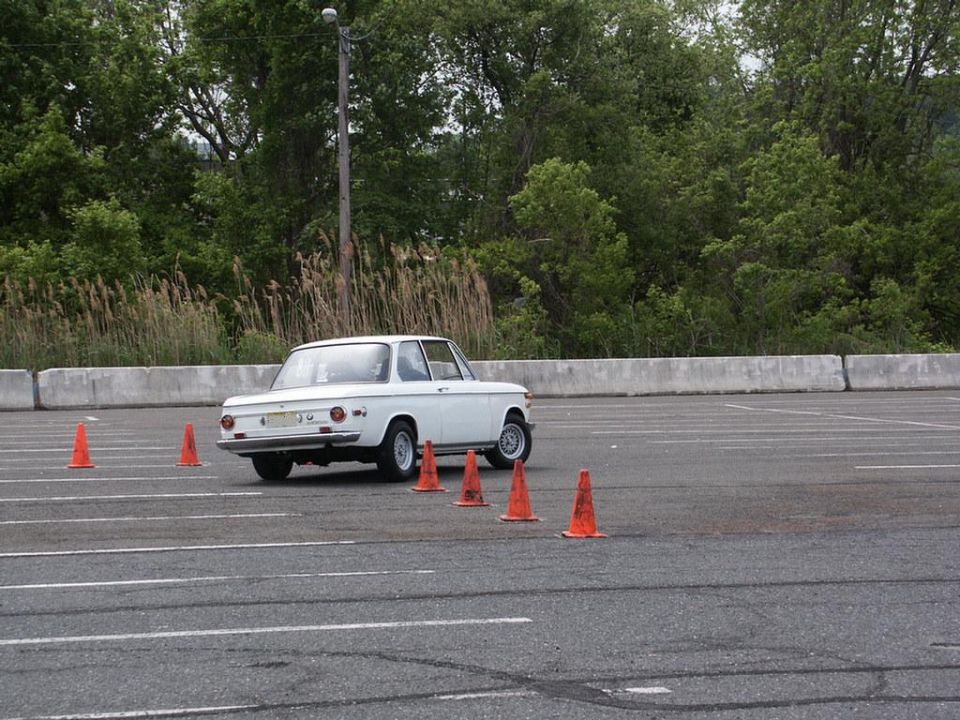 White coupe with orange cones on a track