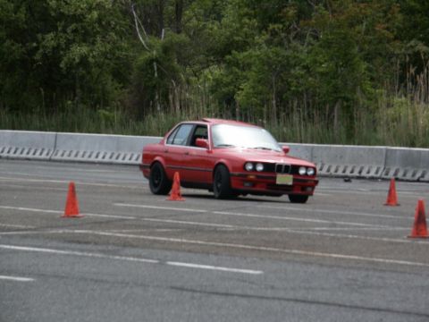 2001 Mercury Grand Marquis - Red sedan navigates a course marked by orange cones on a paved track.