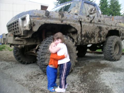 1979 Ford Bronco - Two children embrace in front of a heavily mud-caked 1979 Ford Bronco.