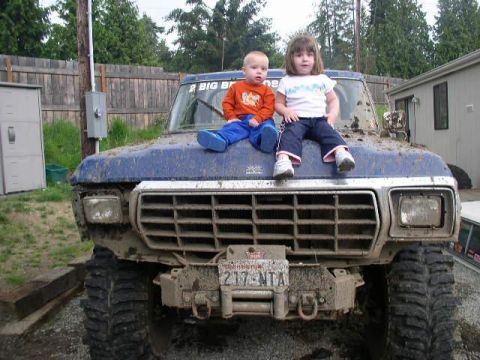 1979 Ford Bronco - Two young children sit atop the hood of a very dirty blue Ford Bronco.