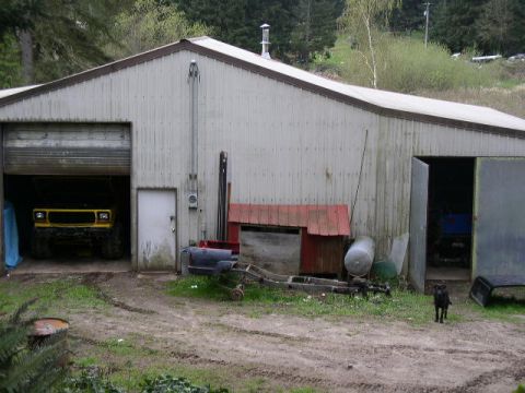 1979 Ford Bronco - A yellow 1979 Ford Bronco is parked inside a garage, partially obscured by a closed door.