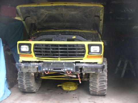 1979 Ford Bronco - Front view of a yellow 1979 Ford Bronco with its hood open, parked inside a garage.