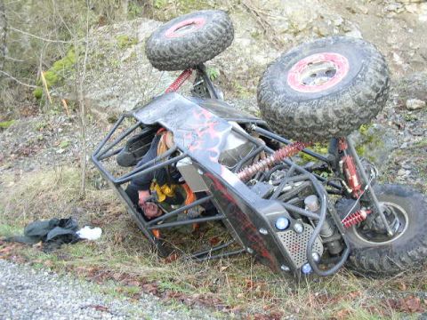 1979 Ford Bronco - An off-road buggy has overturned on a rocky, wooded terrain.