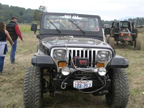 1979 Ford Bronco - A black Jeep Wrangler is parked in a field, with another off-road vehicle in the background.