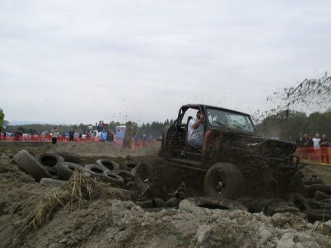 1979 Ford Bronco - An off-road vehicle navigates a challenging mud bog, kicking up a spray of dirt and water.
