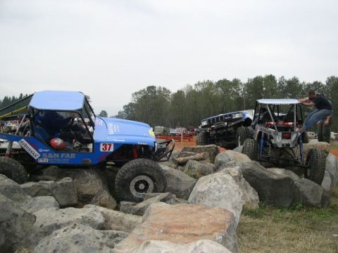 1979 Ford Bronco - Multiple off-road vehicles tackle a challenging rocky terrain course.