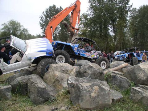 1979 Ford Bronco - Multiple custom off-road vehicles are shown traversing a challenging rocky obstacle course.