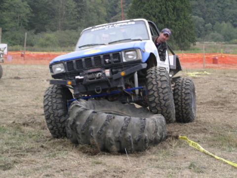 1979 Ford Bronco - Custom Toyota pickup truck navigating an obstacle course with oversized tires.