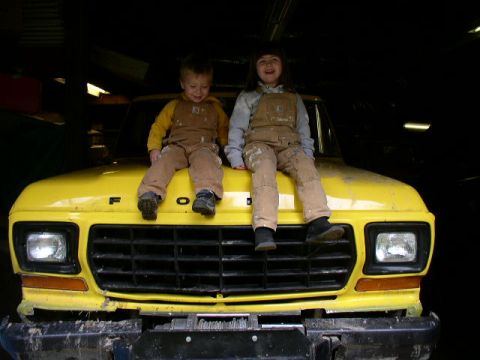 1979 Ford Bronco - Two children sit on the hood of a yellow 1979 Ford Bronco.