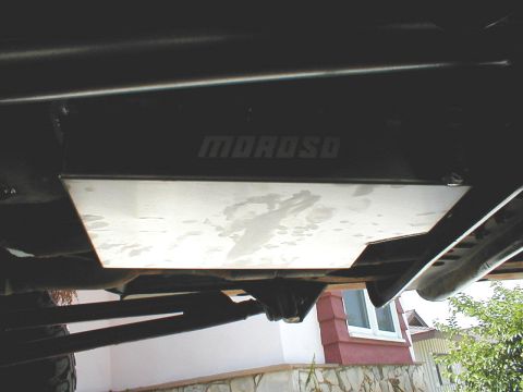 1996 Ford Bronco - Underside view of a vehicle's frame with a Moroso skid plate installed, showing some fluid stains.
