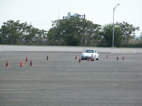 2001 Mercury Grand Marquis - A white sports car navigates a course marked by orange cones in an open lot.