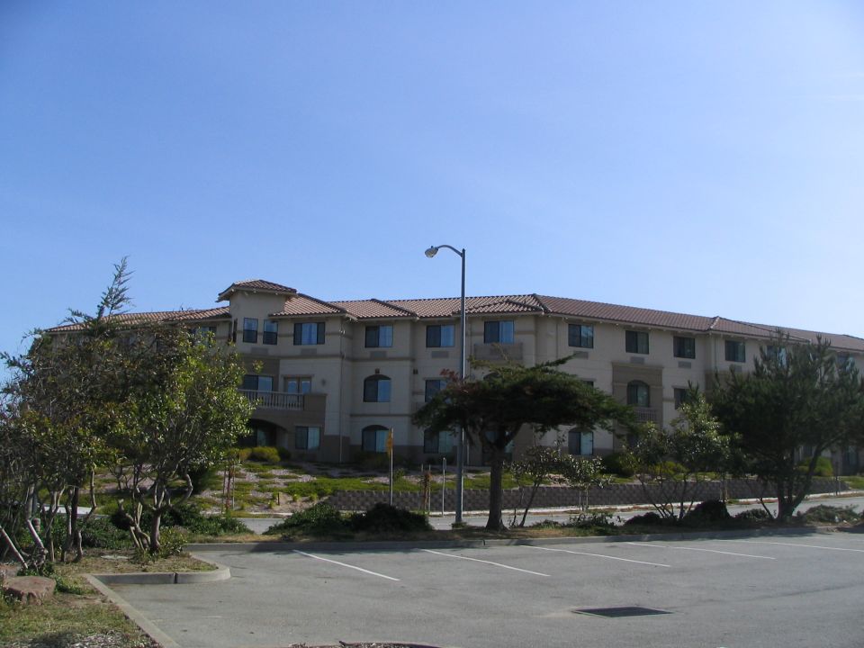 Building with a tiled roof and a parking lot in the foreground