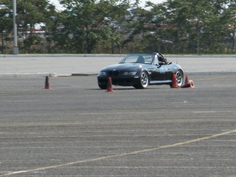 2001 Mercury Grand Marquis - A black BMW Z3 convertible navigates a course marked by orange cones on a paved track.