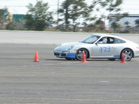 2001 Mercury Grand Marquis - A silver Porsche 911 navigates a race track, marked with blue racing numbers and surrounded by orange cones.