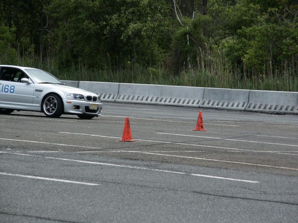 Silver BMW M3 with number 168 on door, on a race track with orange cones