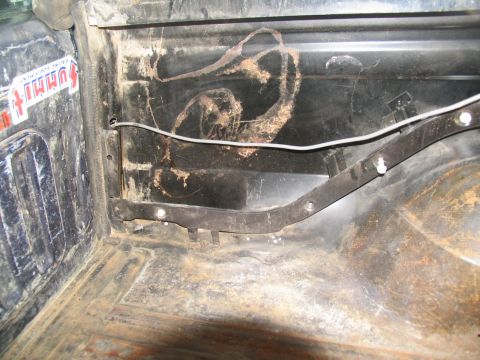 1978 Ford Bronco - Close-up of the interior of a vehicle's cargo area, showing dirt and a sticker.