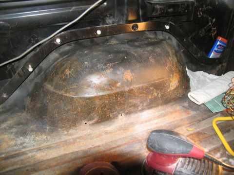 1978 Ford Bronco - The interior of a vehicle's rear wheel well, with a power sander and cleaning supplies visible.