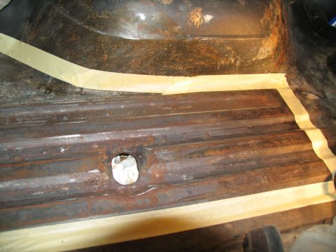 1978 Ford Bronco - Rusted metal floor section with masking tape, likely before priming or painting.
