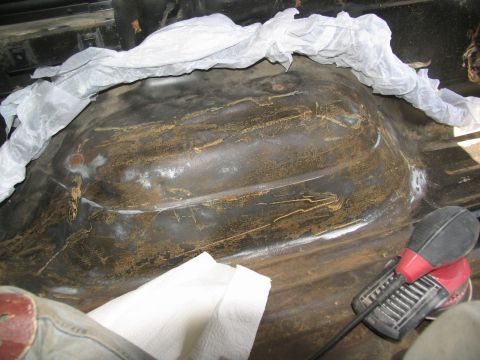 1978 Ford Bronco - Interior floor pan of a vehicle undergoing preparation for priming, showing rust and some primer application.