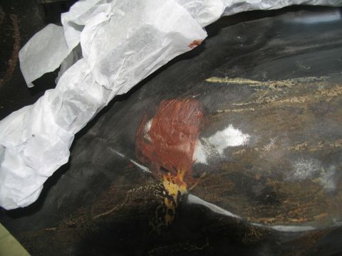 1978 Ford Bronco - A close-up view of a vehicle body panel shows areas of primer and rust, partially covered by protective paper.