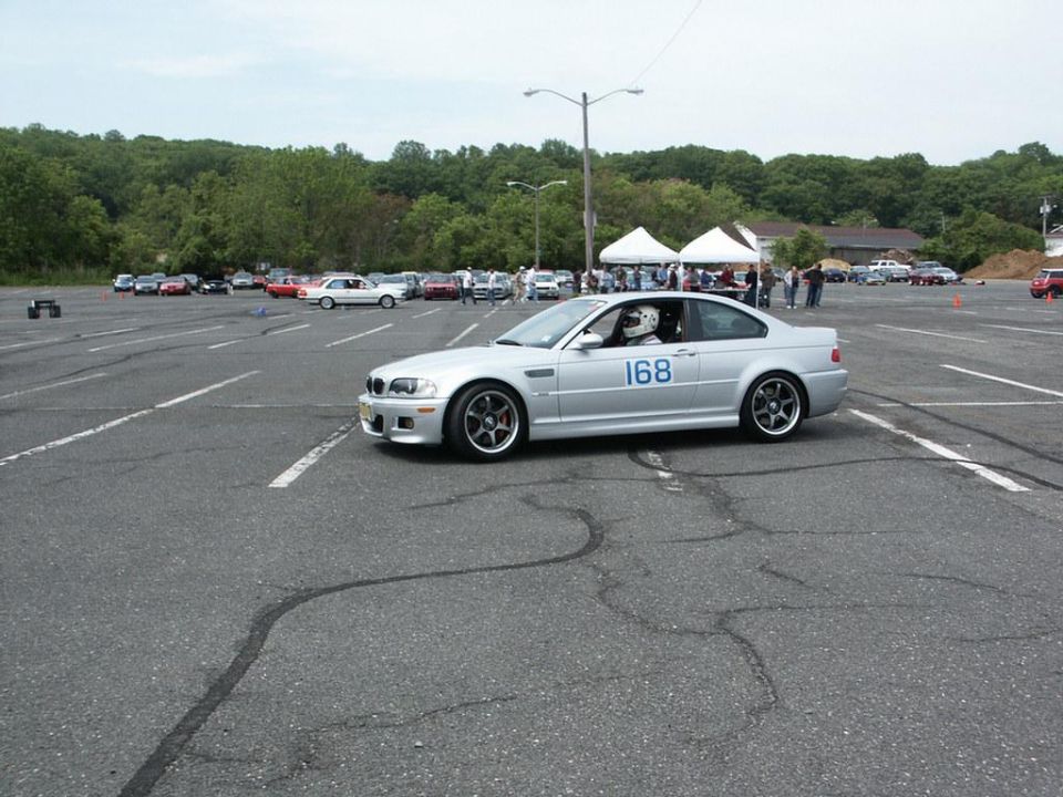 Silver coupe with racing number 168 on door, driver in helmet visible