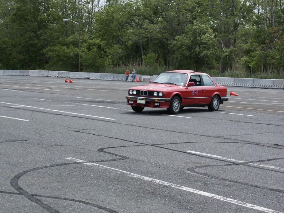 Red BMW coupe with number 241 on door, seen from 3/4 front on a race track