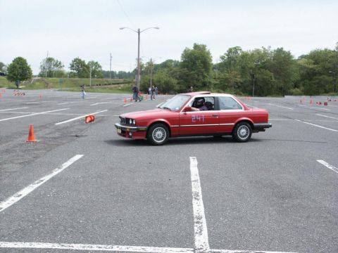 2001 Mercury Grand Marquis - Red coupe with number 241 on door driving on paved lot with cones.