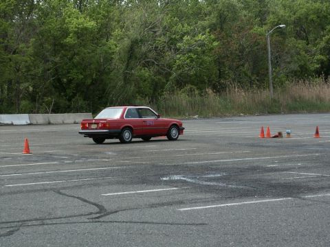 2001 Mercury Grand Marquis - A red coupe navigates a course marked by orange cones on a paved lot.