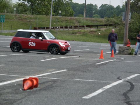 2001 Mercury Grand Marquis - A red Mini Cooper with a white roof and the number 629 on its door navigates an autocross course marked by orange cones.