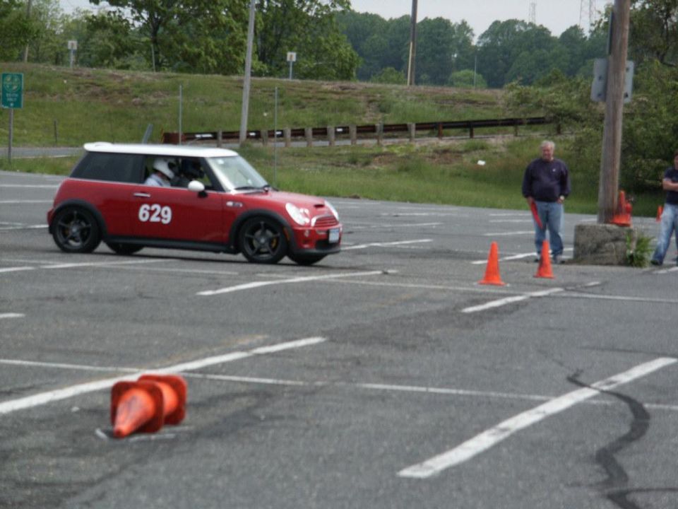 Red Mini Cooper with white roof and number 629 on door, participating in an autocross event