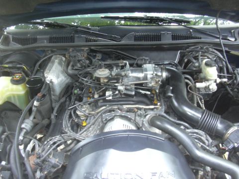 1996 Ford Crown Victoria - Engine bay of a 1996 Ford Crown Victoria, showing the V8 engine and associated parts.
