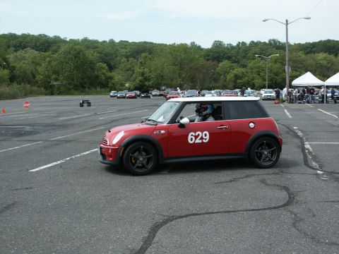 2001 Mercury Grand Marquis - A red Mini Cooper with a white roof and the number 629 on its side is participating in an autocross event.