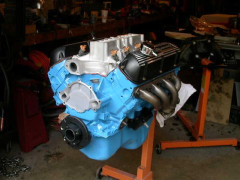 1990 Ford Bronco - A freshly painted engine sits on a stand in a workshop, ready for installation.