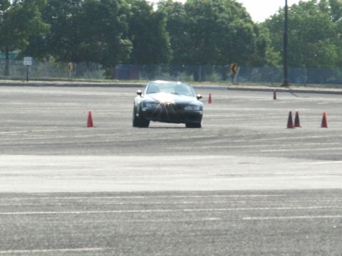 2001 Mercury Grand Marquis - A dark sedan navigates an autocross course marked by orange cones.