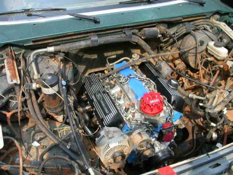 1990 Ford Bronco - Close-up of a Ford V8 engine, aftermarket racing components and visible wiring.