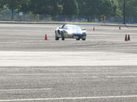 2001 Mercury Grand Marquis - A Lotus Elise navigates an autocross course marked by orange cones on a paved lot.