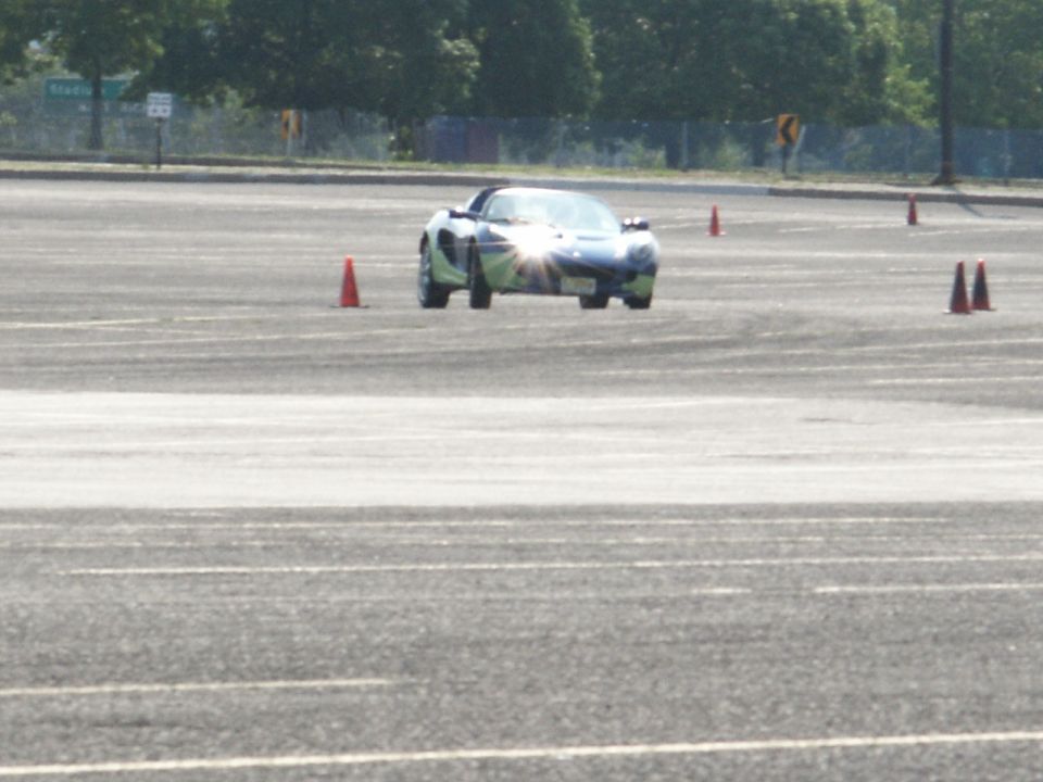 Blue and green Lotus Elise on autocross course with orange cones