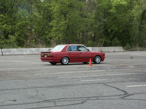 2001 Mercury Grand Marquis - A red sedan navigates an autocross course, marked with racing numbers on its doors.