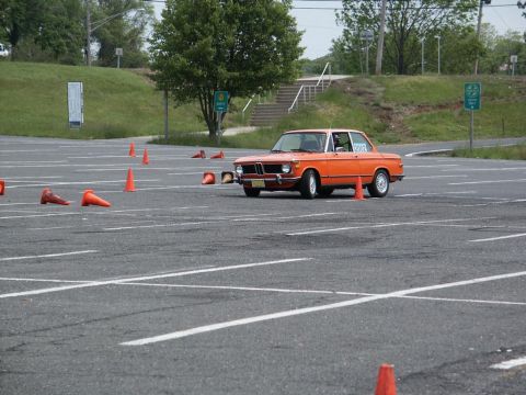 2001 Mercury Grand Marquis - Orange coupe navigates an autocross course marked by traffic cones.