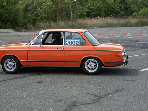 2001 Mercury Grand Marquis - Side view of an orange BMW 2002 at an autocross event, displaying the number 2002.