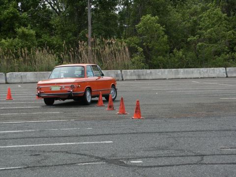 2001 Mercury Grand Marquis - Orange coupe navigates an autocross course marked by traffic cones.
